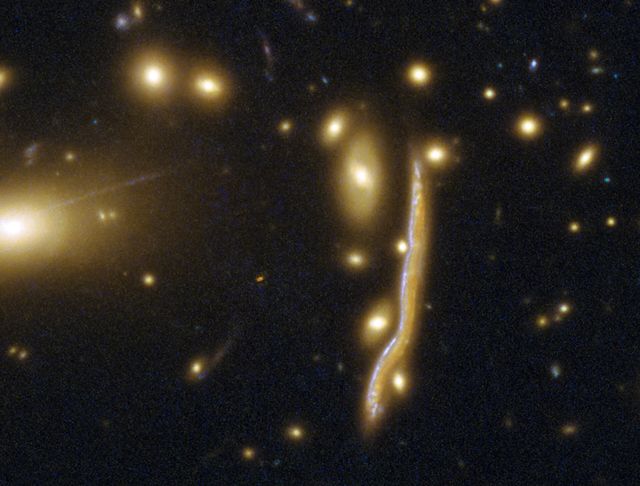 La lontana galassia del serpente cosmico, il serpente cosmico, contiene una famiglia di stelle. [ESA/Hubble, NASA - CC BY 4.0]