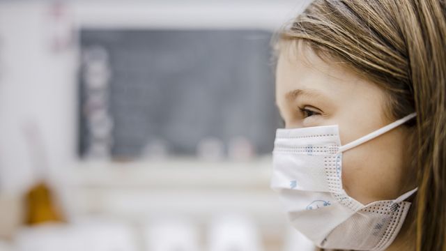 Une élève d'une école primaire portant le masque. [Michael Buholzer - Keystone]