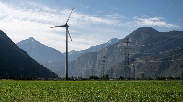 L'éolienne Cime de l'est, haute de 100 mètres, dont les pales s'élèvent à 134 mètres du sol et qui produit 2 MW d'énergie électrique, est photographiée entre les pylônes du réseau électrique à haute tension, ce lundi 1er juillet 2019, à Collonges, en Valais. [Laurent Darbellay - KEYSTONE]
