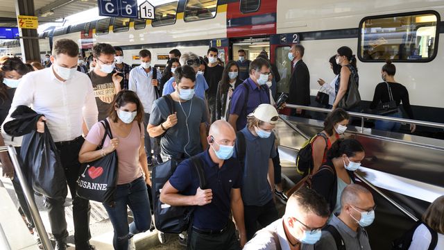 Des voyageurs portant le masque dans la gare de Lausanne. [Laurent Gillieron - Keystone]