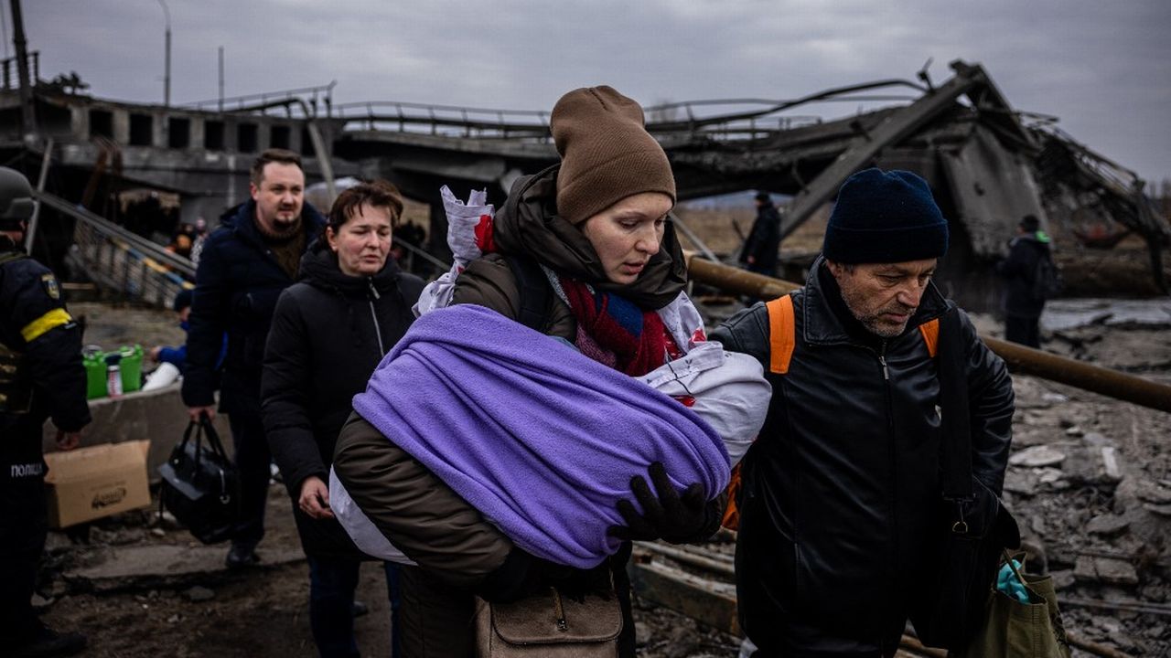 Une mère et son bébé en train de fuir la ville d'Irpin, au nord de Kiev. [Dimitar Dilkoff - AFP]