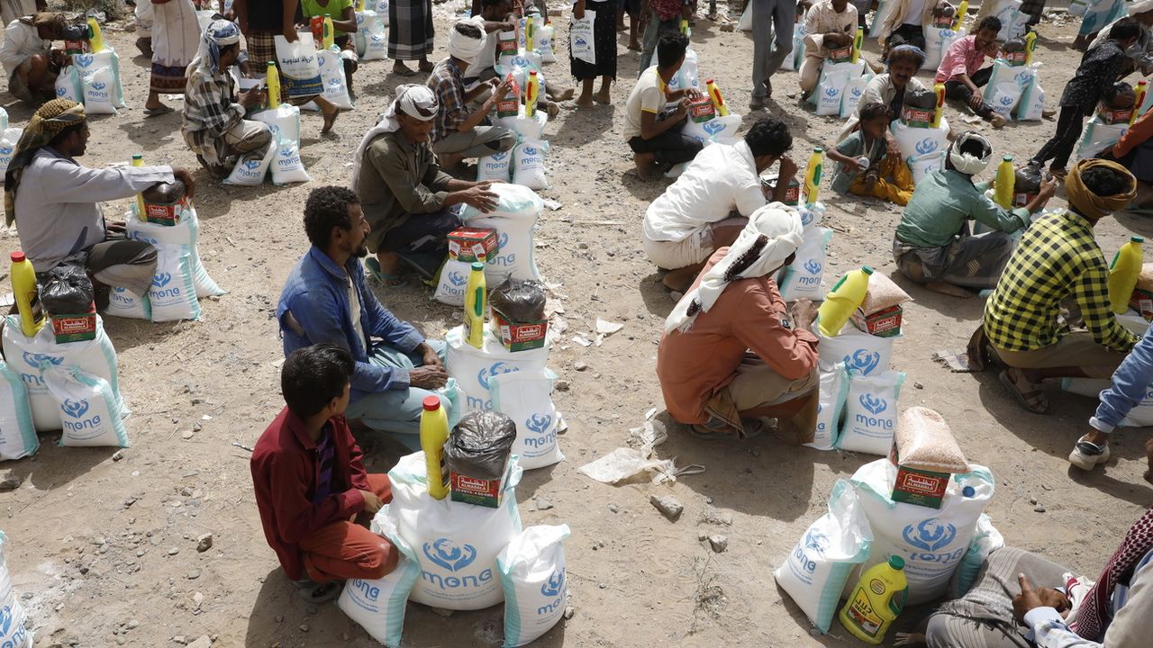 Des personnes reçoivent une aide alimentaire dans la ville d'al-Jarahi, dans la province portuaire de Hodeidah, au Yémen, le 10 février 2022. [EPA/YAHYA ARHAB - Keystone]