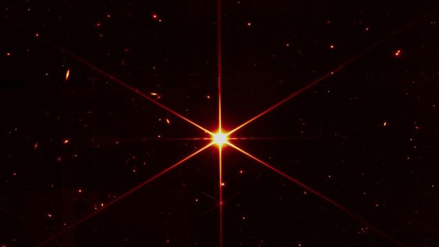 Alors que le but de cette image était de se concentrer sur l'étoile brillante au centre pour évaluer l'alignement, l'optique de Webb et le NIRCam sont si sensibles que les galaxies et les étoiles vues apparaissent en arrière-plan. [JWST - NASA/STScI]