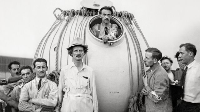Auguste Piccard portant un chapeau avec Max Cosyns dans la nacelle du ballon stratosphérique. [Keystone]