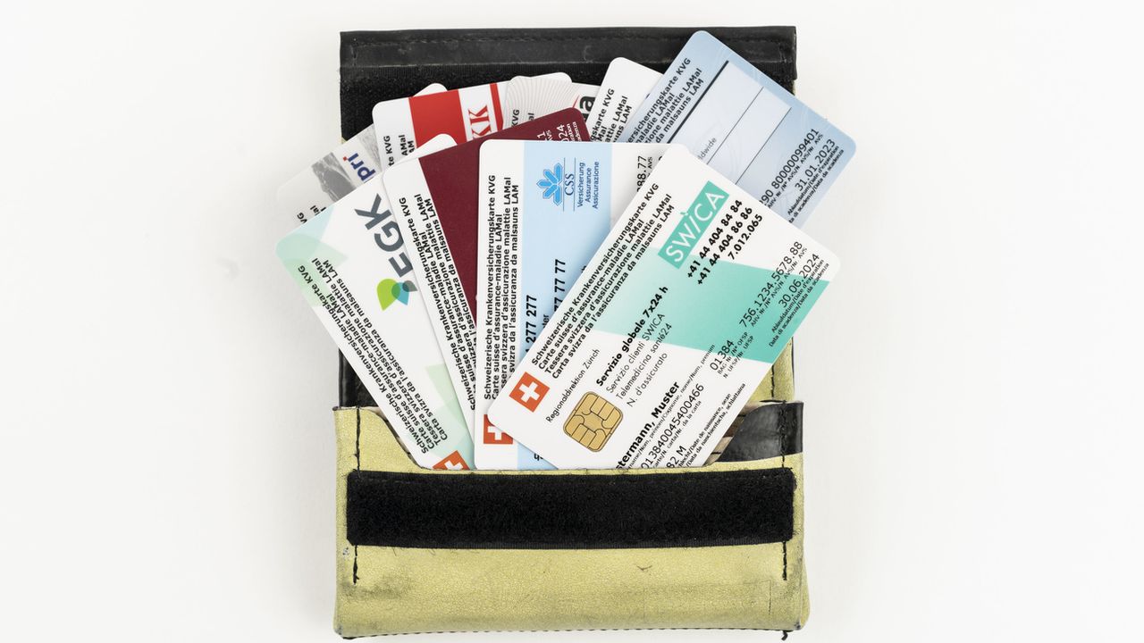 Différentes cartes d'assurance maladie suisses dans un porte-monnaie, photographiées à Zurich, Suisse, le 9 septembre 2019. [Christian Beutler - KEYSTONE]