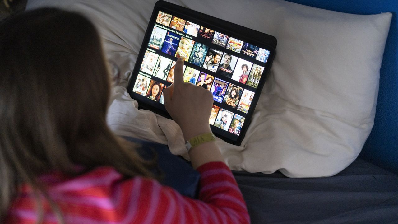 Une femme utilise la plateforme de streaming Netflix sur sa tablette. [Gaëtan Bally - Keystone]
