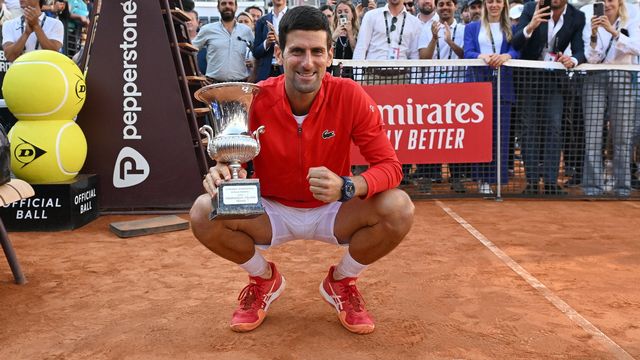 Novak Djokovic tout sourire avec le trophée à la main. [Ettore Ferrari - Keystone]