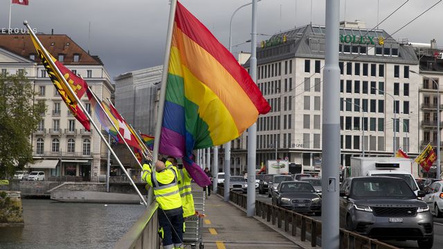 Des employés de la ville de Genève installent un drapeau pour une campagne LGBTIQ+ en 2021. [Salvatore Di Nolfi - Keystone]