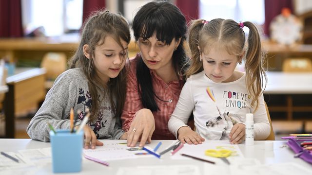 Deux enfants réfugiées d'Ukraine et leur enseignante à Herisau, en Appenzell, le 13 mai 2022. [Gian Ehrenzeller - Keystone]