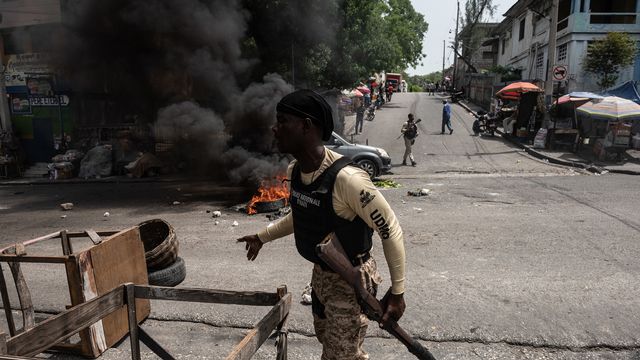 Des policiers ramassent des pneus sur les barricades lors d'une manifestation citoyenne pour dénoncer l'insécurité et les enlèvements constants, à Port-au-Prince, Haïti, le 19 mai 2022. [Johnson Sabin - EPA/KEYSTONE]