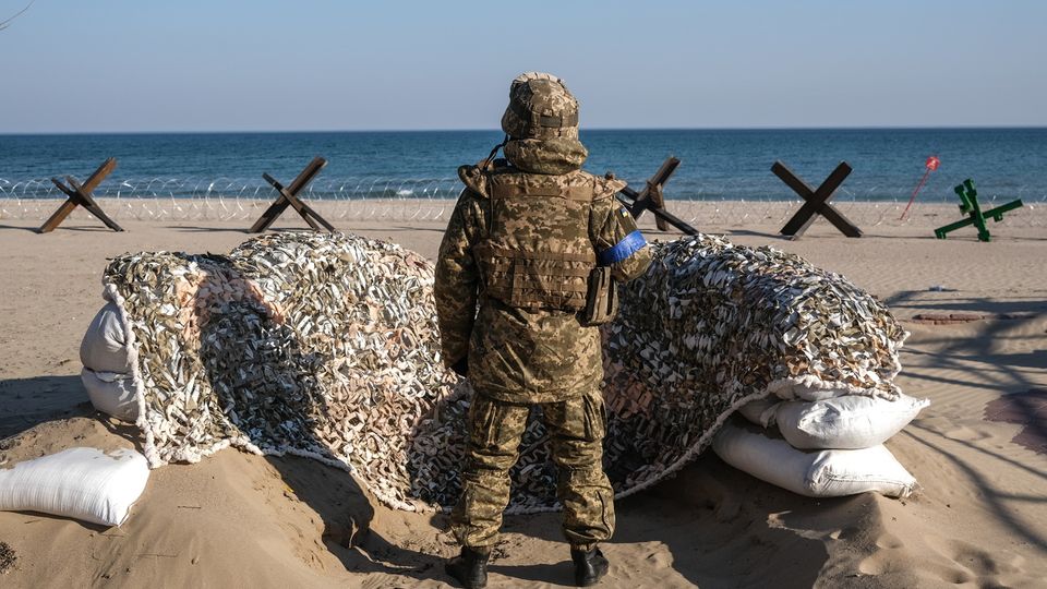 Un soldat ukrainien monte la garde sur une plage, au sud d'Odessa, alors qu'au large, des navires russes imposent un blocus maritime à Kiev. [Seda Suna - keystone]