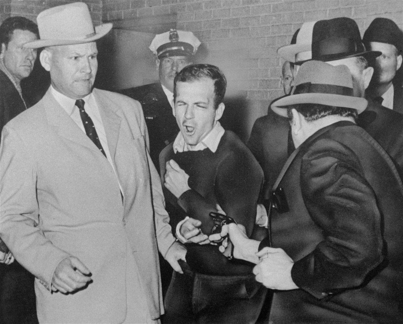 Lee Harvey Oswald (au centre), l'assassin présumé du président John F. Kennedy, est abattu le 24 novembre 1963 dans un couloir du quartier général de la police de Dallas par Jack Ruby (de dos, à droite), propriétaire d'une boîte de nuit. Avant son procès, Ruby a déclaré: "On ne saura jamais la vérité, ni pourquoi j'ai agi. Les personnes qui ont tant à gagner et un motif puissant pour me mettre où je suis ne laisseront jamais éclater la vérité."