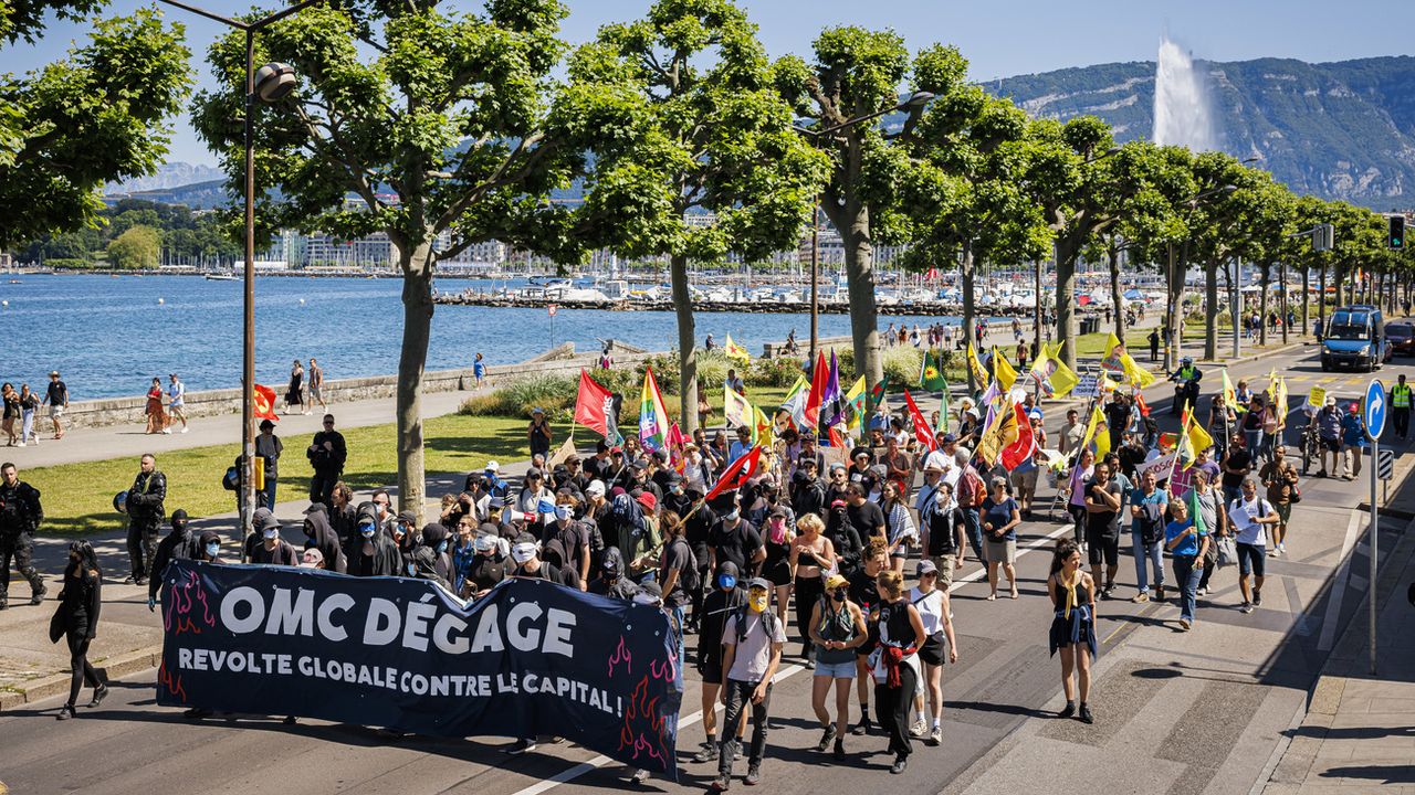 Des personnes défilent à Genève lors d'une manifestation contre l'Organisation mondiale du commerce (OMC) à la veille de sa 12e Conférence ministérielle. [Valentin Flauraud - KEYSTONE]