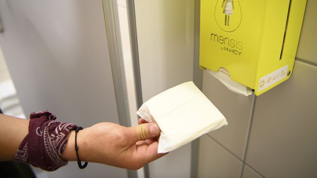 Un distributeur de serviette hygiéniques dans les toilettes d'un collège. [Laurent Gillieron - Keystone]