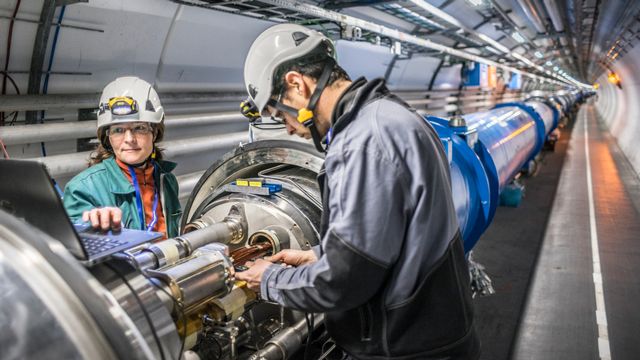 Deux personnes travaillent dans le tunnel du LHC. CERN, le 27 janvier 2014. [Anna Pantelia - CERN]