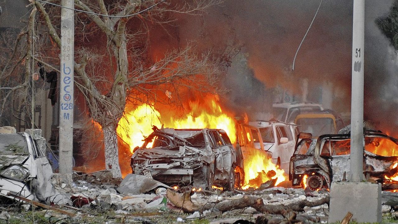 Des voitures en feu après l'attentat à la bombe contre l'hôtel Ambassador à Mogadiscio, en Somalie, revendiqué par le groupe affilié à Al Qaïda al-Shabaab en 2016. Image d'illustration. [MOHAMED ABDIWAHAB  - AFP]