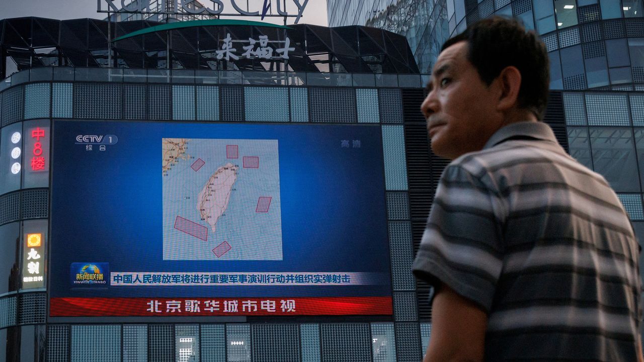 FILE PHOTO: A man stands in front of a screen showing a CCTV news broadcast, featuring a map of locations around Taiwan where Chinese People's Liberation Army (PLA) was to conduct military exercises and training activities including live-fire drills, at a shopping center in Beijing, China, August 3, 2022. REUTERS/Thomas Peter/File Photo [Thomas Peter - reuters]