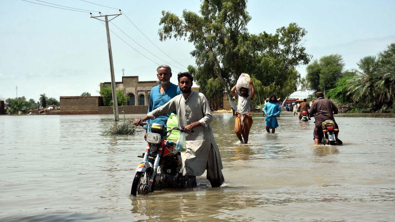 Des personnes pataugent dans une zone inondée suite à de fortes pluies dans le district de Kamber Shahdadkot, province de Sindh, Pakistan, le 29 août 2022 [Waqar Hussain - EPA]