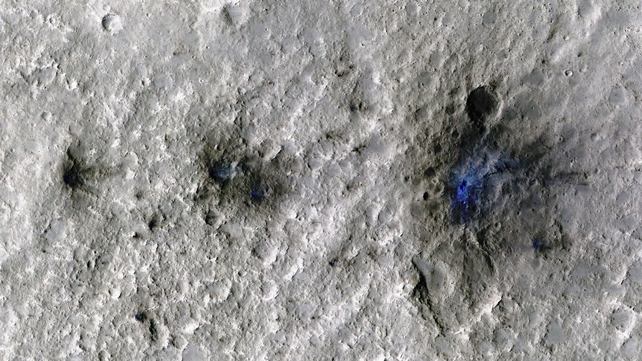 InSight a détecté des impacts de météorites pour la première fois, le 5 septembre 2021, sur Mars. Mars Reconnaissance Orbiter a ensuite pris cette image des impacts, teintés en bleu afin de les mettre en évidence. [JPL-Caltech/University of Arizona - NASA]