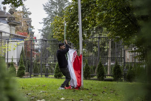 Un manifestant a enlevé le drapeau iranien à l'ambassade de Berne. [Peter Klaunzer - Keystone]