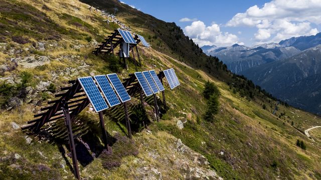 Une vue sur les panneaux solaires installés sur des paravalanches dans les Alpes le mercredi 3 août 2022 à Bellwald (VS). [Jean-Christophe Bott - Keystone]