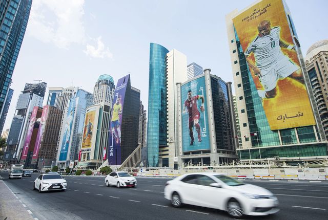 The towers of Doha are adorned with images of footballers, on the eve of the kick-off of the World Cup in Qatar. [Noushad Thekkayl - EPA/Keystone]