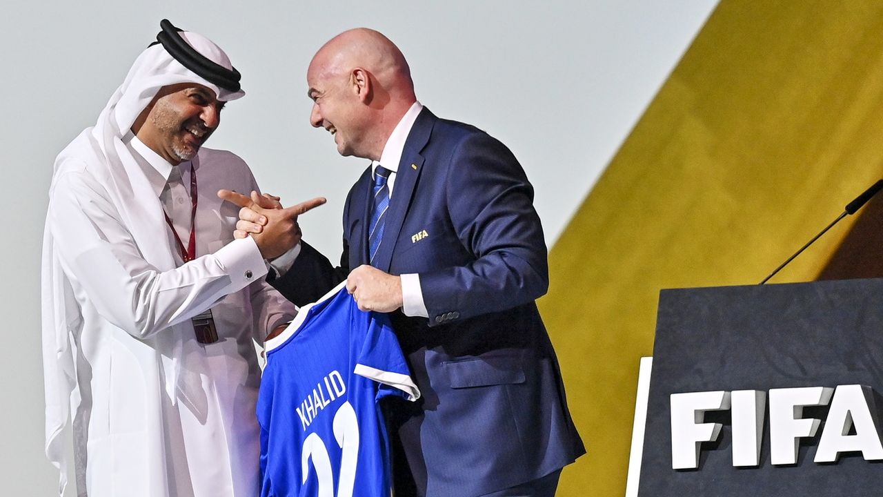 Le président de la FIFA Gianni Infantino remet un maillot au Premier ministre du Qatar. [EPA/Noushad Thekkayil - Keystone]