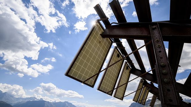 Des panneaux solaires installés sur des paravalanches dans les alpes valaisannes, à Bellwald. [Jean-Christophe Bott - KEYSTONE]