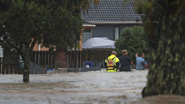 Des secouristes et un homme pataugent dans les eaux à Auckland, en Nouvelle-Zélande, le 27 janvier 2023. [Hayden Woodward/New Zealand Herald via AP - Keystone]