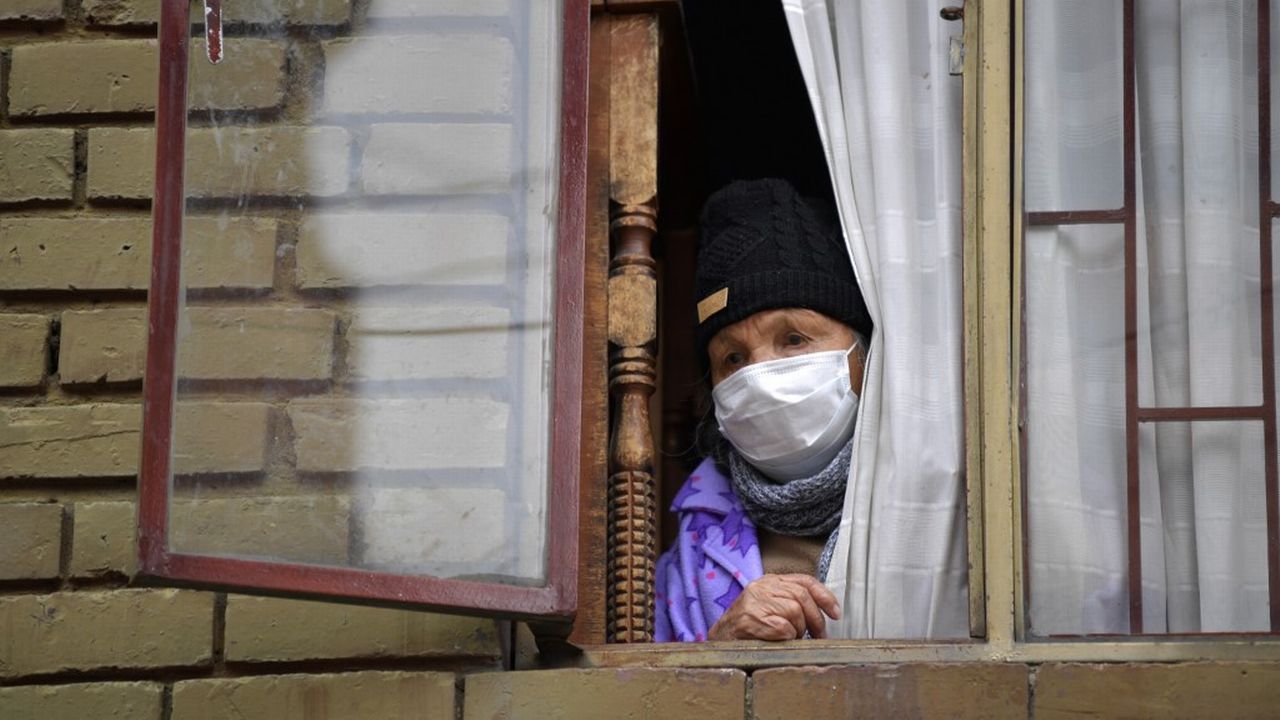 Une personne âgée regarde par la fenêtre dans le quartier de Kennedy, une des zones de Bogota qui connaît un grand nombre de contaminations au Covid-19. Colombie, le 3 juin 2020. [Raul Arboleda - AFP]