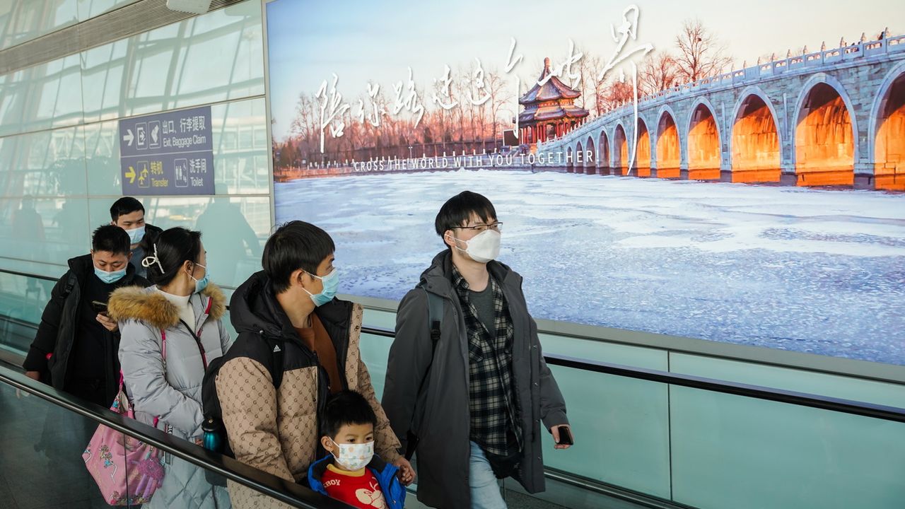 Des passagers à l'aéroport de Pékin. [EPA/Wu Hao - Keystone]