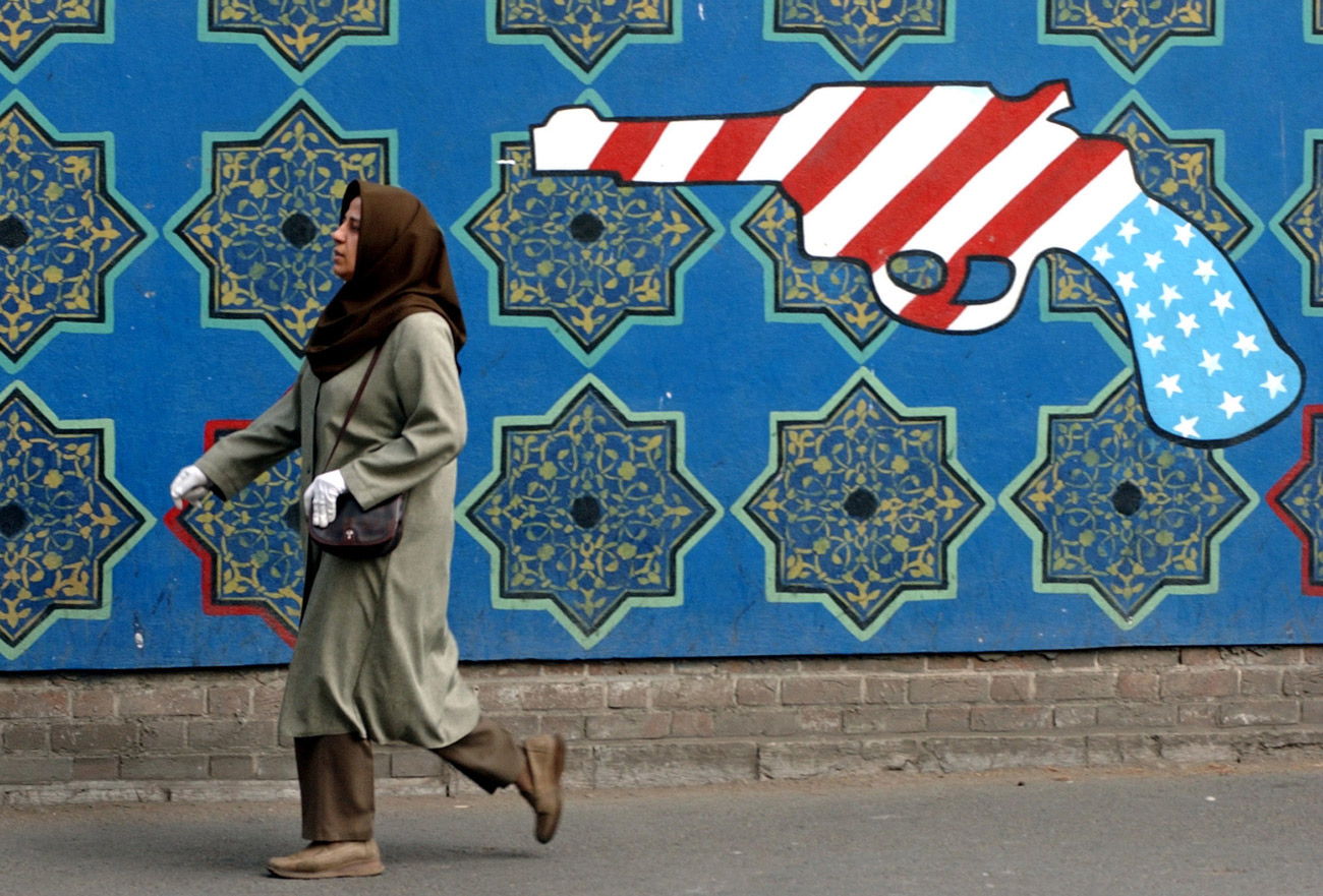 Une Iranienne passe devant un graffity anti-américain peint sur le mur de l'ancienne ambassade des Etats-Unis à Téhéran, le 3 novembre 2004.