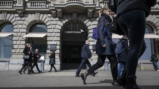 Les gens passent devant le bâtiment principal de Credit Suisse à Zurich, le 16 mars 2023. [Ennio Leanza - Keystone]