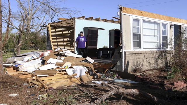 Yvonne Hayes regarde le tas de débris, le samedi 25 mars 2023, après que le toit et le mur de sa maison aient été enlevés par une tempête la nuit précédente à Amory. [Keystone]
