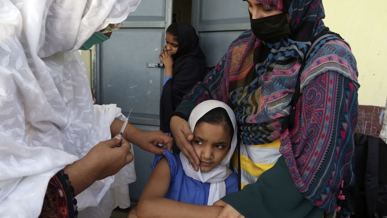 Une écolière reçoit une dose de vaccin contre la typhoïde à Peshawar au Pakistan. [Muhammad Sajjad - Keystone]