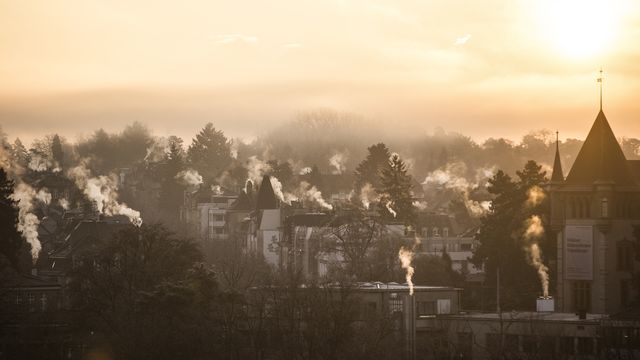 Des cheminées crachent de la fumée en ville de Berne le 14 décembre 2016. [Peter Klaunzer - Keystone]