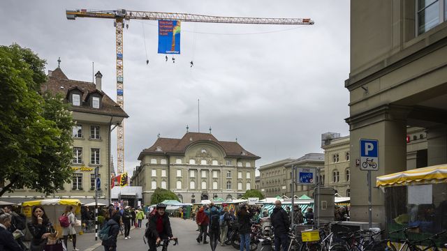 Des militants de Greenpeace se sont suspendus à une grue près du Palais fédéral à Berne. [Peter Klaunzer - Keystone]