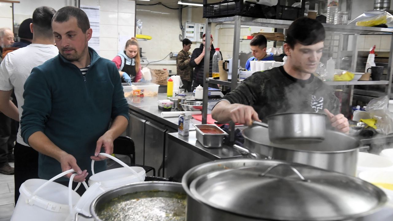 Des personnes préparent un repas pour les soldats ukrainiens engagés au front, dans la cuisine d'un restaurant de Kharkiv, le 22 mars 2022. [Andrzej Lange - EPA/Keystsone]