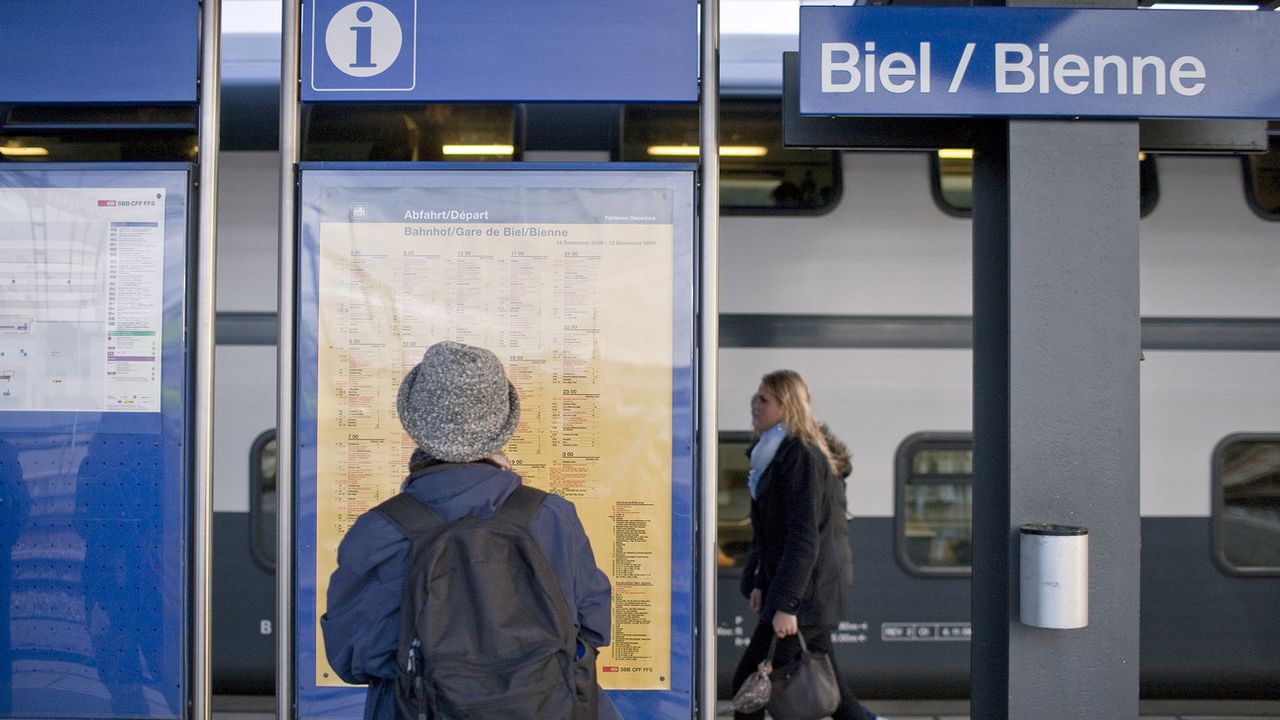 Une femme consulte un horaire CFF à la gare de Bienne le 27 novembre 2009.  [Gaetan Bally - Keystone]