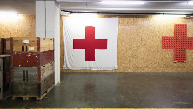 Un drapeau de la Croix-Rouge suisse est accroché à un mur du centre logistique de la CRS à Wabern, le 7 janvier 2020.  [Gaetan Bally - KEYSTONE]