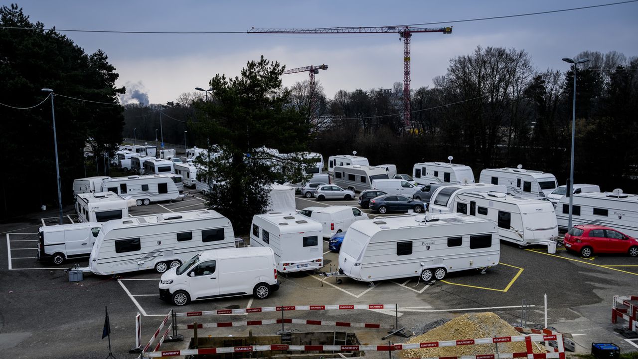 Des gens du voyage avec des caravanes en provenance de France stationnent sur le parking de la Bourdonnette, le samedi 4 mars 2023. [Jean-Christophe Bott - Keystone]
