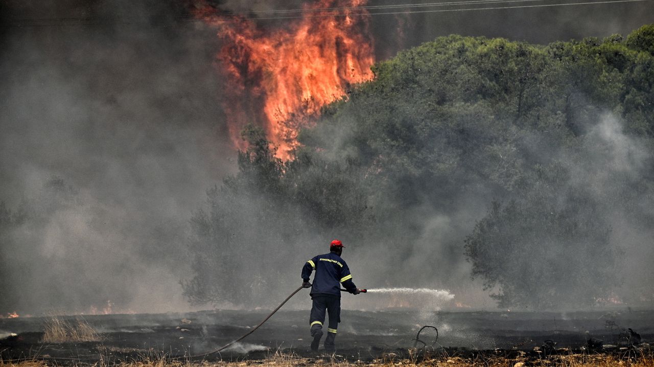 Un pompier luttant contre les gigantesques feux de forêt en Grèce en juillet 2023 (image d'illustration). [Vasilis Psomas - EPA/Keystone]