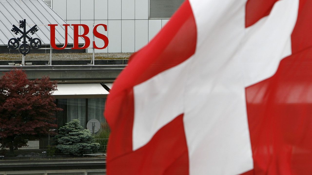 Le logo d'UBS derrière un drapeau suisse, à Zurich. [Alessandro Della Bella - Keystone]