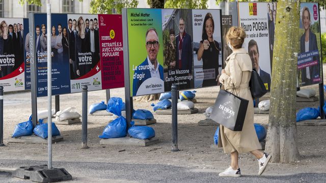 Une personne passe devant les affiches de la campagne pour les élections fédérales le jeudi 28 septembre 2023 à Genève. [Martial Trezzini - Keystone]