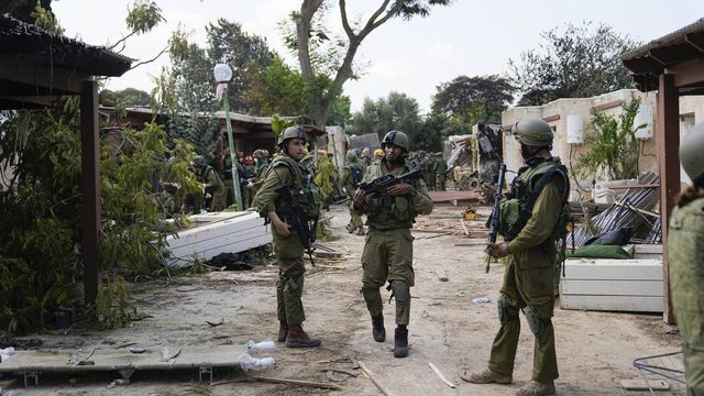 Des soldats israéliens dans le kibboutz Kfar Azza, où le Hamas a tué et enlevé plusieurs personnes. [Keystone]